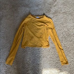 A cropped honey mustard long sleeve shirt